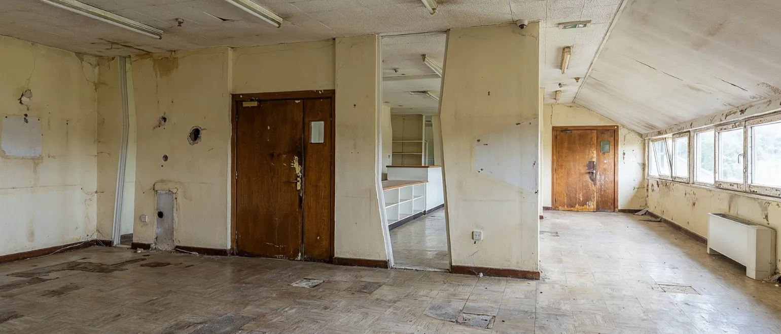 Before HOA remodeling services project in Los Angeles showing worn common area interior, damaged walls, outdated flooring, old doors, and neglected shared residential space
