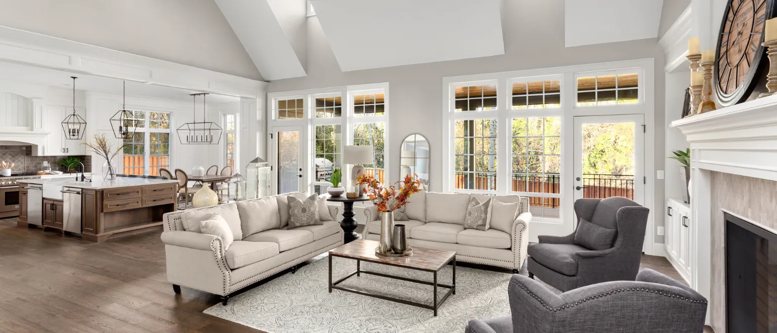 After luxury home remodeling project in Los Angeles with open-concept living room, vaulted ceiling, premium kitchen view, fireplace feature wall, natural light, and elegant interior design